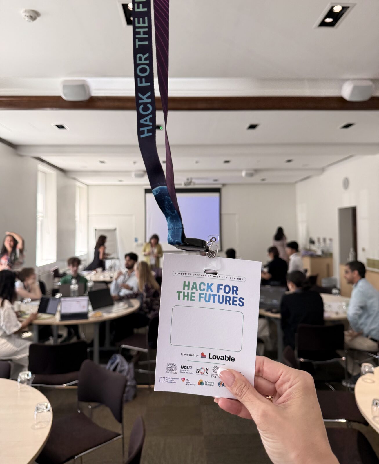A Hack for the Futures event badge held up inside the London Climate Action Week venue.