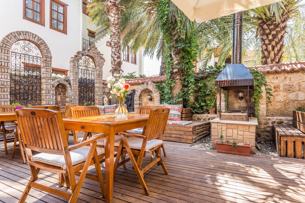 Stone arches, palms, and outdoor tables at GYC House.